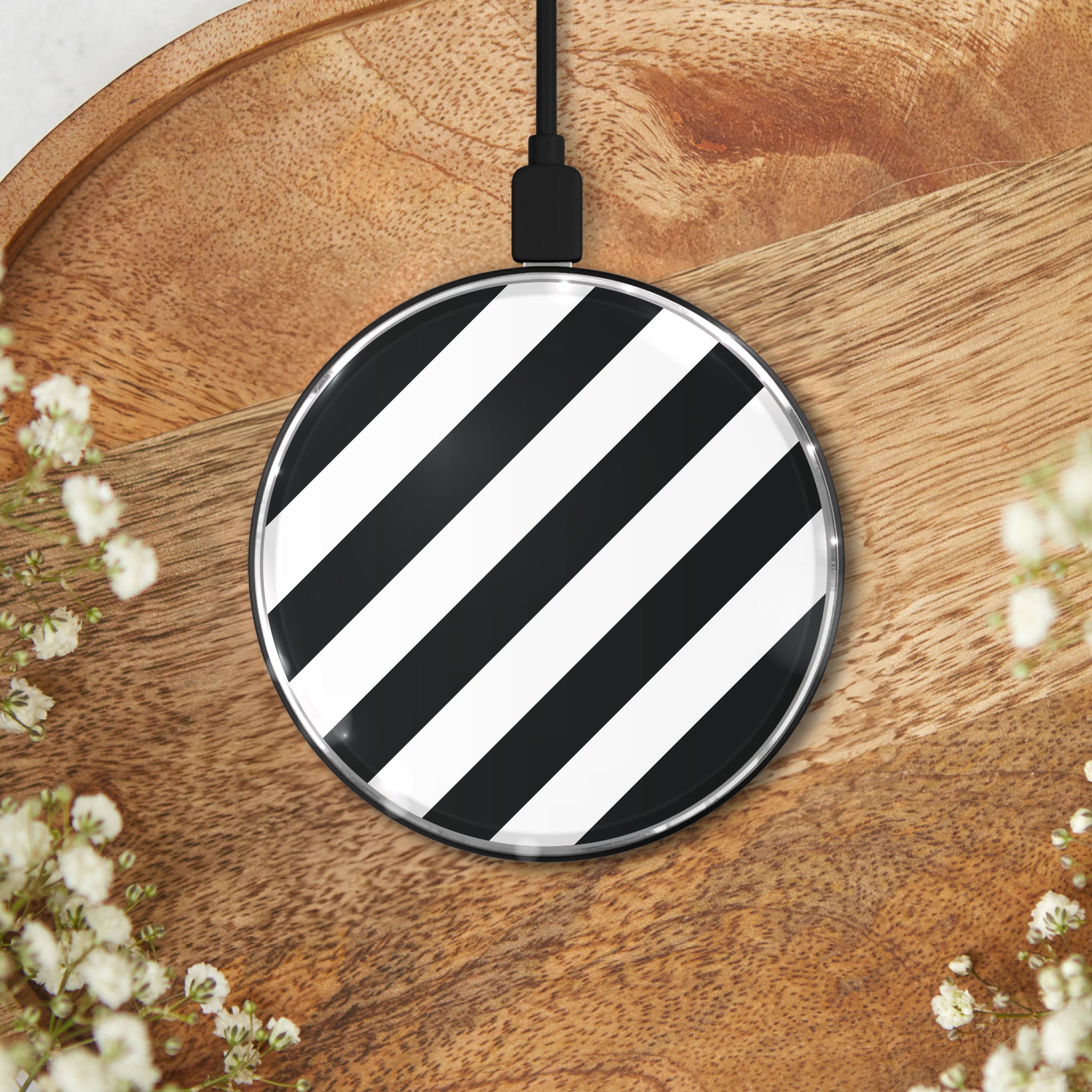 Minimalist black and white striped wireless charging pad on a wooden surface